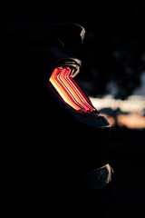 Vertical closeup shot of a black sports car red backlight at night