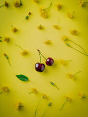 ripe cherries on yellow background top view. Pattern of fresh red  cherries with sprig . ummer Creative layout. flat lay