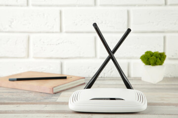 Wireless Wi-Fi router on white background with notebook