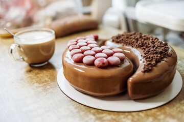 Lovely delicious cake in the home kitchen on a wooden table and a fragrant cup of coffee