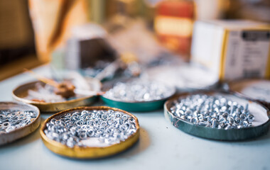 Small metal nuts bolts and a wrench lie on the work table of the assembler
