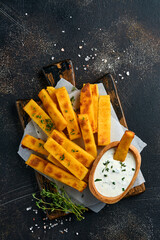 Homemade polenta chips fries with sea salt, parmesan, thyme, rosemary with yogurt sauce. Typical...