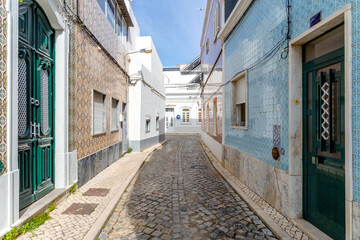 Narrow street with traditional fishermen's houses in Olhao, Portugal