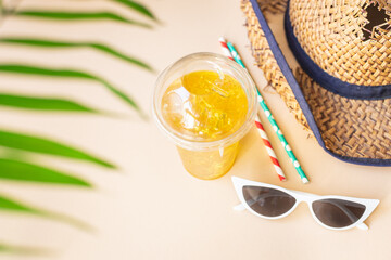 Fototapeta na wymiar background tropical leaf palm lemonade refreshing cold ice drink, straw hat, sunglasses relax accessories summer vacation positive mood vacation top view