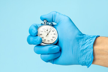 Doctor in glove holds stopwatch in his hand. Fast medical assistance and consultation concept