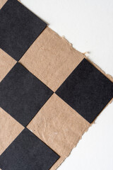 black squares of paper on craft paper with a deckle edge on white