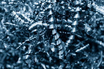 Close-up scene of metal scrap from turning process. The pile of lathe chips. - obrazy, fototapety, plakaty