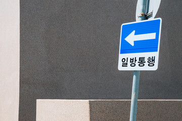 One way traffic sign and gray wall in Korea