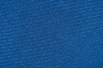 Blue texture of fabric from a textile material for an abstract background for an empty surface and for wall-paper.