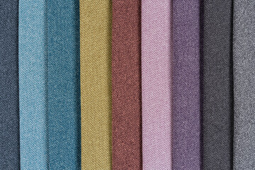Fototapeta premium Multi-colored samples of woven textiles. Catalog and palette tone of Interior fabric for furniture, closeup.
