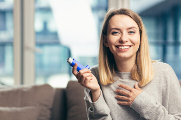 Beautiful girl smiling at camera while holding inhaler 