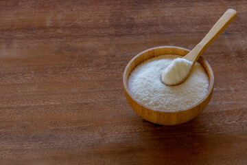 bamboo bowl with caster sugar on rustic wooden board. health concept. avoid sugar. space for text