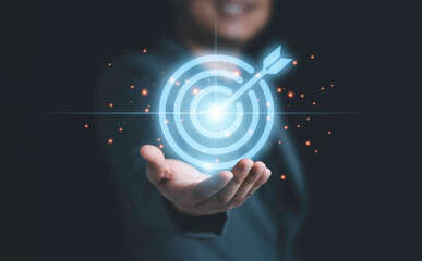 Businessman holding virtual blue dartboard with arrow ,Business Achievement objective target...