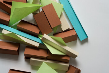 folded green paper squares with paper objects in blue yellow and brown