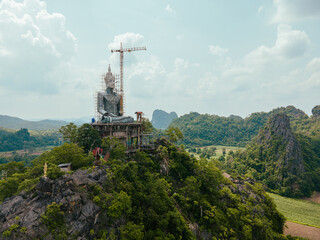Obraz premium Aerial view construction buddha statue in the temple on the mountain. Engineering construction big buddha statue on the mountain. 