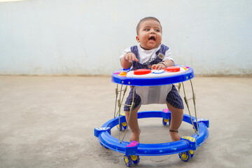 Cheerful Indian child in the baby walker.