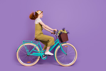 Profile side view portrait of attractive cheerful girl riding cycle fast air blowing hair isolated...