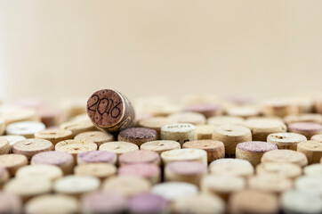 Closeup macro of corks with sign 2016 and stamped withe on wine corks mosaic. Soft light, selective focus, shallow depth of field, blurred background. Space for copy. Wine advertising culture concept.