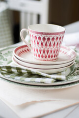 Cup and saucers on table. Swedish design. Vintage, retro scandinavian design. On table, green napkin. Lillemor Gefle.