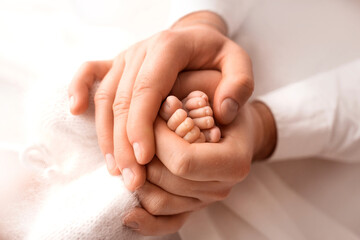 Children's feet in hold hands of mother and father. Mother, father and Child. Happy Family people...