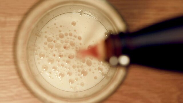 Pouring ale beer into a glass top view