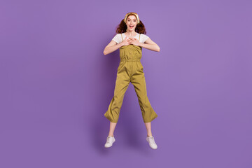 Fototapeta na wymiar Full length body size view of attractive cheerful amazed girl jumping isolated over violet purple color background
