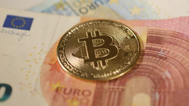 Bitcoin coin on top of 10 Euro bill. Close up. 