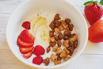 Frühstück mit Beeren.
Joghurt mit Erdbeeren und Bananen