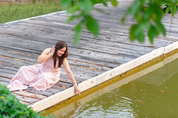 Beautiful woman sitting relaxing on wooden bridge