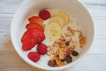 Frühstück mit Beeren.
Joghurt mit Erdbeeren und Bananen