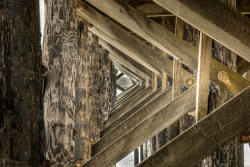 Fototapeta na wymiar Triangular wooden construction under a pier in California