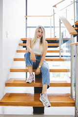 Vertical shot of a Hispanic female sitting on wooden stairs