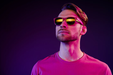 Portrait of attractive serious successful guy wearing specs looking far away isolated over dark neon purple color background