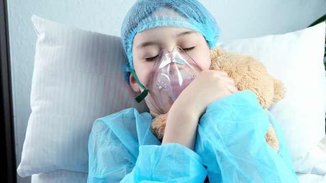 Little Patient In Shirt, Child, Boy Lies With Teddy Bear, Facial Oxygen Mask, Concept Of Medical Care, Anesthesiology And Intensive Care, Oxygen Therapy, Treatment Of Coronavirus, COVID-19