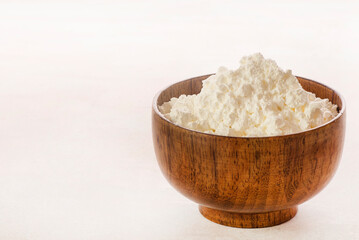 Corn flour in wooden bowl close up