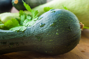 Still life - fresh whole zucchini, eggplant and parsley on a wooden board, close up