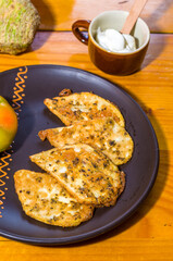 Vegetarian food - celery tuber slices fried in batter in a ceramic plate on a wooden table, close up