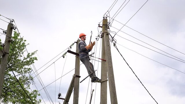 The electrician connects the lighting cable in the village.