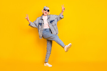 Fototapeta na wymiar Full length body size view of elderly retired pensioner trendy cheerful woman showing v-sign dancing isolated over bright yellow color background