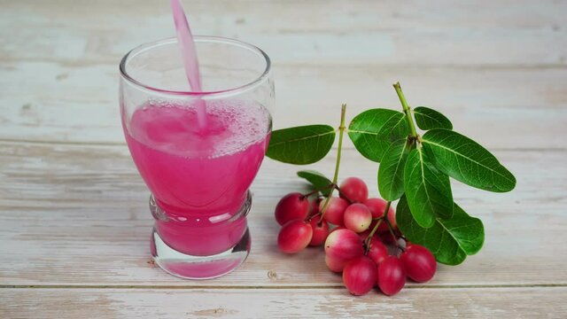 Pour Iced Karanda fruit juice Put down a glass, Bengal-Currants, Carandas-plum, Karanda, Carissa carandas L, Is a fruit with high medicinal properties.