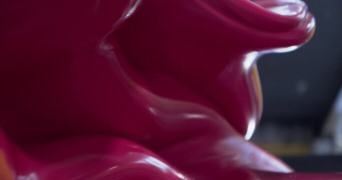 Industrial plastic red mixture blending in the machinery, close up