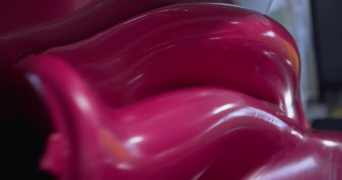 Industrial amalgam of moldable plastic material, red blob, close up