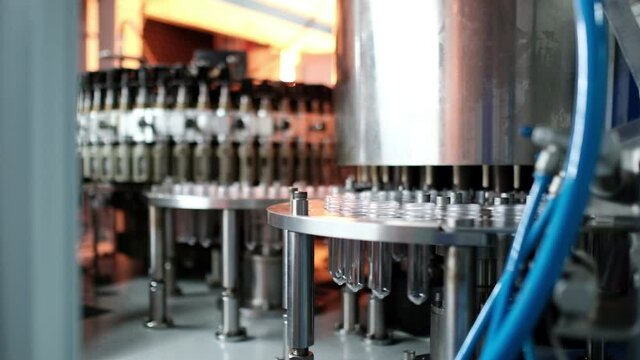 Conveying preforms through a heat sink to form water bottles in an automatic blow molding machine to produce drinking water.