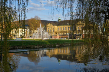 Blick über sie Fränkische Saale auf den Rosengarten und die große Wasserfontäne von Bad Kissingen