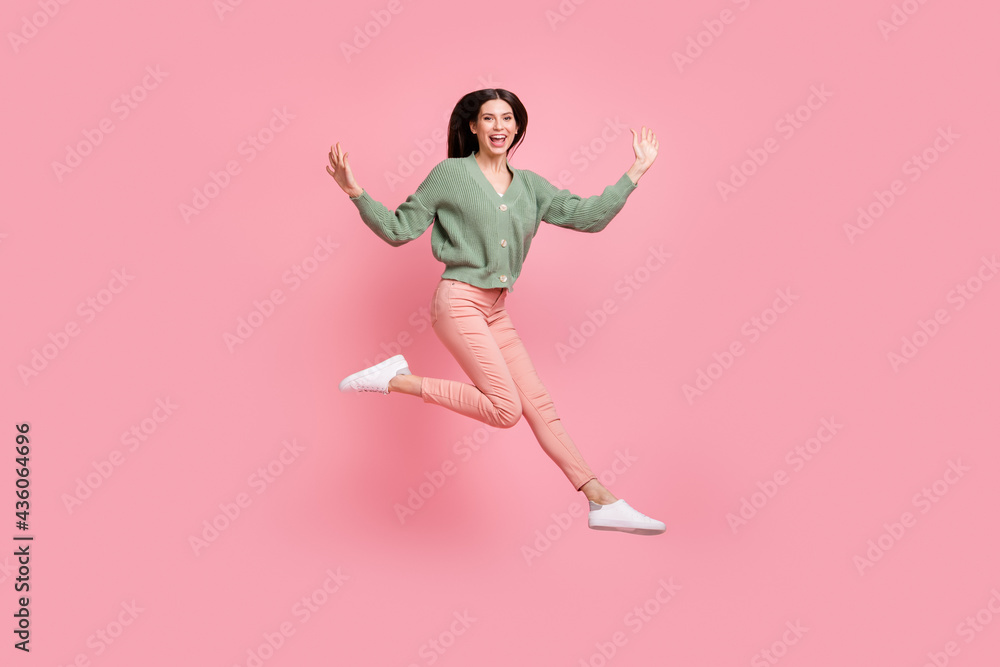 Wall mural Full size photo of optimistic cool girl jump wear sweater trousers sneakers isolated on pink color background