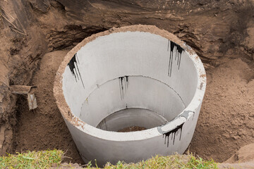 Concrete sewer rings in the ground. Construction or repair of sewerage on an industrial site
