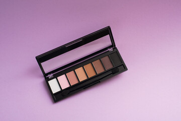palette of basic eyeshadows on a purple background. Makeup concept