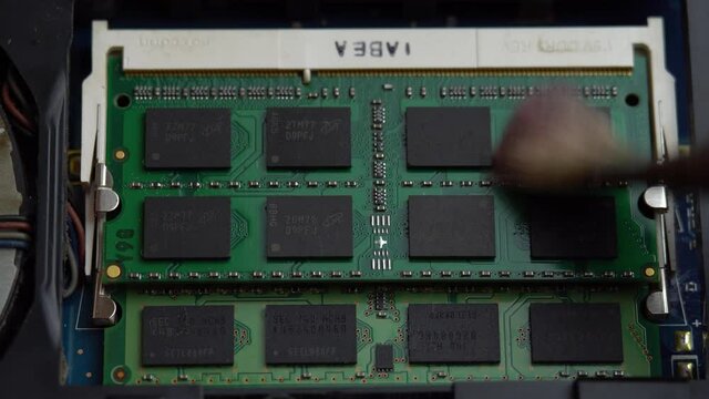 Removing dust from laptop RAM with a brush, cleaning laptop parts