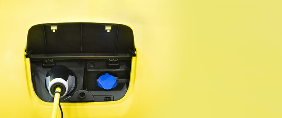 Front view yellow electric car charging with copy space, Technology electric vehicle concept