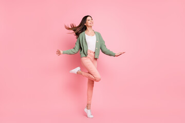 Full size photo of optimistic girl dancing look empty space wear sweater trousers sneakers isolated...